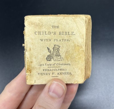 Miniature children's bible book held in hand